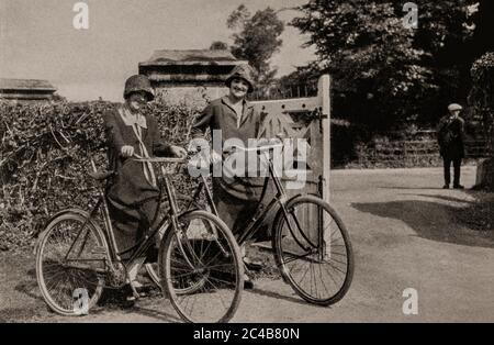 Une scène de deux jeunes femmes au début des années 1920, à vélo près de Killarney, qui fait maintenant partie du parc national de Killarney dans le comté de Kerry. Initialement photographié par Clifton Adams (1890-1934) pour 'Ireland: The Rock Wharce I was hewn', un reportage du magazine National Geographic de mars 1927. Banque D'Images