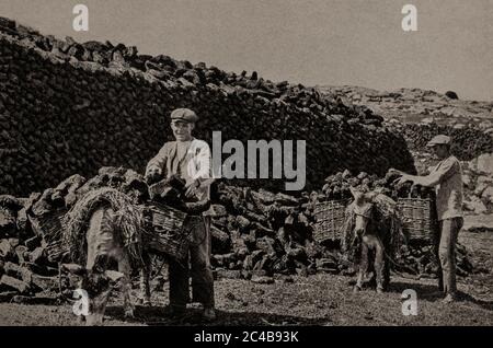 Une vue du début des années 1920 des habitants et de leurs ânes qui ramassaient du gazon (ou de la tourbe) en été pour les feux d'hiver. Initialement photographié par A. W. Cutler (1875-1935) pour 'Ireland: The Rock Wharce I was hewn', un reportage du magazine National Geographic de mars 1927. Banque D'Images