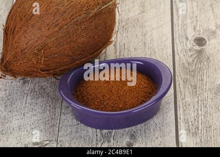 Le sucre brun de noix de coco dans le bol sur fond de bois Banque D'Images