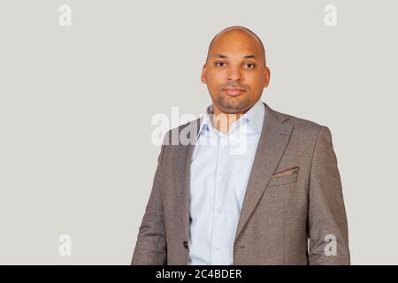 Un jeune homme afro-américain noir élégant et confiant, dans une chemise et une veste, un look élégant, confiant dans son succès, avec une expression sérieuse sur son visage. Un aperçu simple et naturel de l'appareil photo Banque D'Images