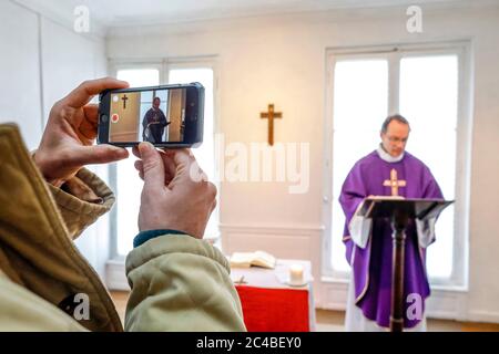 Messe dans un oratoire catholique pendant l'épidémie de COVID-19 à Evreux, France, filmée pour les fidèles qui ne peuvent assister à la messe à cause de l'isolement. Banque D'Images