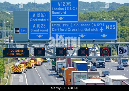 Panneaux routiers gros plan et panneaux électroniques d'information numériques pompiers services d'urgence accident de la circulation fermé trois voies M25 Brentwood UK Banque D'Images