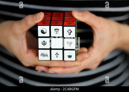 Femme avec un cube de rubik avec des symboles religieux Banque D'Images