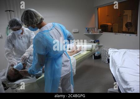 Services d'urgence de l'hôpital d'Abbeville, soins dans la région de Covid d'un patient présentant des symptômes d'infection. Une infirmière accompagne le patient pour un sc Banque D'Images