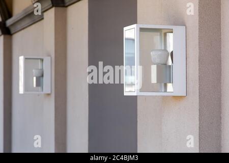 lanterne carrée à charnières sur le mur dans un coffret en fer avec un verre et une lampe blanche. Banque D'Images