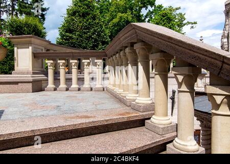 coin d'un balcon avec des balustrades et des balustrades en pierre sur l'escalier de l'architecture de rue avec des arbres. Banque D'Images