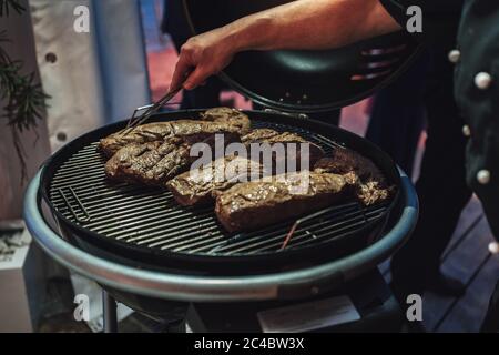 Plusieurs morceaux de viande sur le gril, préparation du repas. Homme prenant soin de repas. Célébration, barbecue, concept de fête Banque D'Images