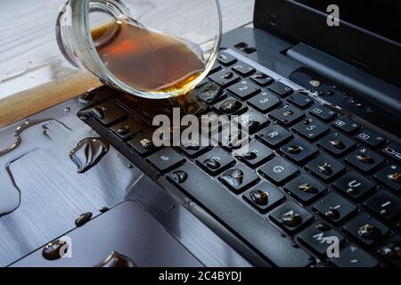 Du café a été renversé par accident sur un ordinateur portable. Le clavier est plein de liquide et l'ordinateur est en ruine. Banque D'Images