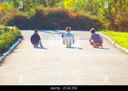 Trois garçons skateboard . Enfants jouant ensemble Banque D'Images