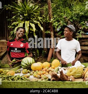 Jeunes hommes vendant des fruits dans les rues de Morro de sao paulo, Brésil, Amérique du Sud Banque D'Images