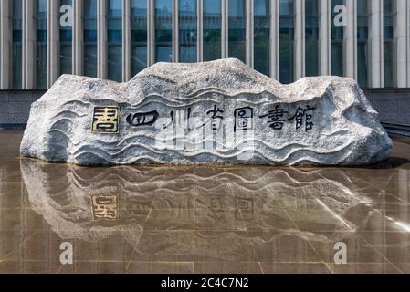 Chengdu, province du Sichuan, Chine - 24 juin 2020 : Rock avec inscription - Sichuan Library - en caractères chinois reflétant dans un bassin devant le bâtiment de la bibliothèque du Sichuan près de la place Tianfu au centre de la ville par une journée ensoleillée Banque D'Images