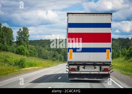 Un camion avec le drapeau national du Costa Rica représenté sur la porte arrière transporte des marchandises vers un autre pays le long de la route. Concept d'exportation-importation,t Banque D'Images