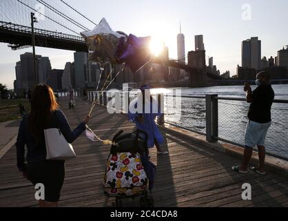 Brooklyn, États-Unis. 26 juin 2020. Une fille célèbre sa remise des diplômes au Brooklyn Bridge Park le jeudi 26 juin 2020. La ville de New York est entrée dans la phase 2 d'un plan de réouverture en quatre parties lundi après avoir été fermée pendant 3 mois en raison de la COVID-19. Photo de John Angelillo/UPI crédit: UPI/Alay Live News Banque D'Images