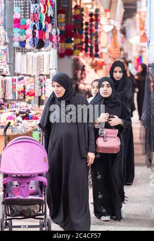 Muscat / Oman - 15 février 2020: Les femmes musulmanes locales portant des boutiques d'abaya noir dans le marché couvert de bazar voûté de Mutrah Souq Banque D'Images