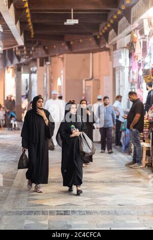 Muscat / Oman - 15 février 2020: Les femmes musulmanes locales portant des boutiques d'abaya noir dans le marché couvert de bazar voûté de Mutrah Souq Banque D'Images