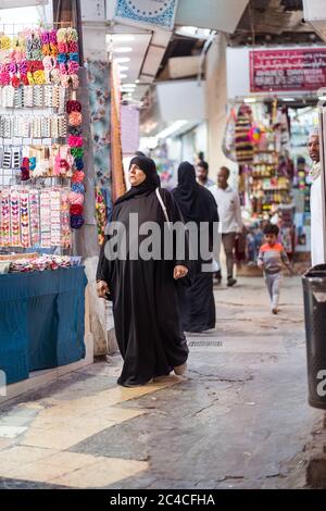 Muscat / Oman - 15 février 2020: Les femmes musulmanes locales portant des boutiques d'abaya noir dans le marché couvert de bazar voûté de Mutrah Souq Banque D'Images