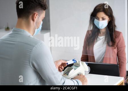 Caissier de la boutique ou réception de l'hôtel avec masque médical Banque D'Images