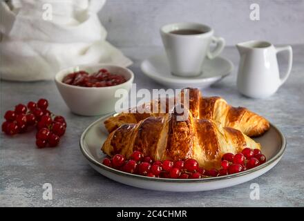 Croissants au beurre frais avec baies, confiture et café. Banque D'Images