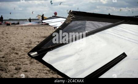 Voile noir et blanc d'un planche à voile sur la plage, arrière-plan flou Banque D'Images