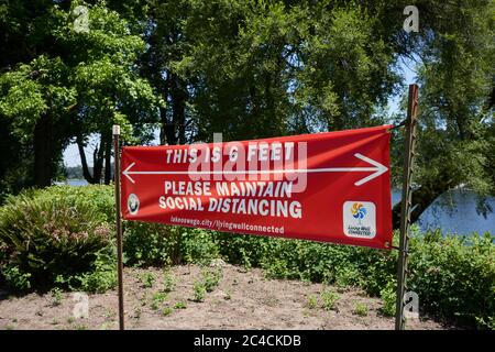 Une bannière sociale de distanciation est vue dans un parc municipal du lac Oswego, en Ontario, car de nombreux États constatent une augmentation des cas de coronavirus dans la crise pandémique. Banque D'Images