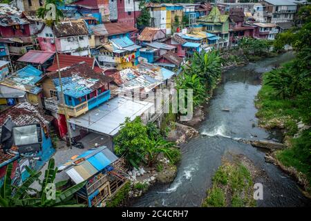 Maisons colorées étroitement regroupées le long d'une rivière en Indonésie. Banque D'Images