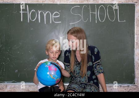 Mère étudie une carte du monde sur un globe avec son fils. Banque D'Images