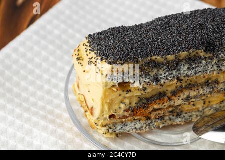Morceau de gâteau avec graines de pavot sur une plaque de verre gros plan Banque D'Images