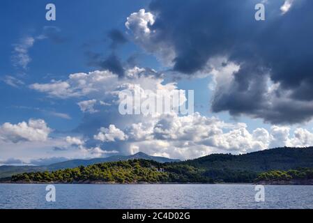 Vue sur la rive depuis la mer. Panorama avec la mer et nuages orageux dans le ciel. Sithonia, Halkidiki, Grèce. Banque D'Images