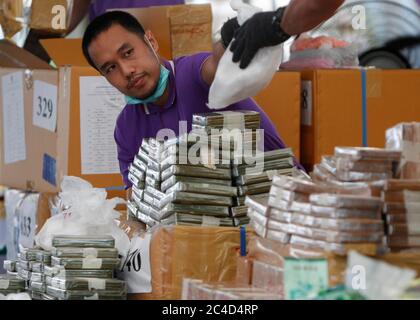 Un responsable thaïlandais des stupéfiants organise des sacs d'héroïne lors de la 50e cérémonie de destruction des stupéfiants confisqués pour marquer la Journée internationale contre l'abus et le trafic illicite de drogues.plus de 25,301 kg de drogues, dont la méthamphétamine, la marijuana, l'héroïne et l'opium, d'une valeur de plus de 55,941 millions de baht, Ont été détruits au moment où le gouvernement thaïlandais a commencé sa campagne anti-drogue, selon le ministère thaïlandais de la Santé publique. Banque D'Images