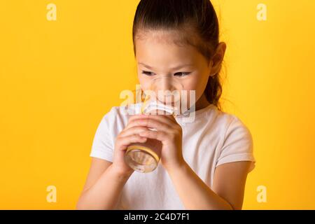 Portrait d'un enfant asiatique joyeux qui boit de l'eau douce Banque D'Images