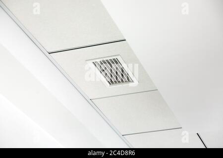 plafond en plaques de plâtre blanc à plusieurs niveaux et plafond suspendu carré avec grille de ventilation. Banque D'Images