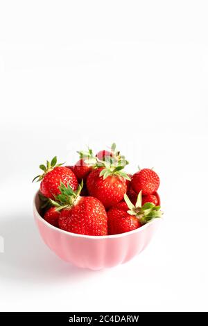 Bol avec fraises fraîches sur fond blanc. Composition estivale Banque D'Images