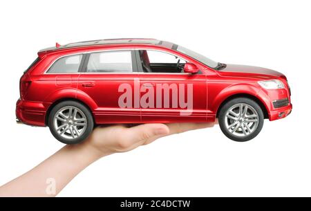 Kiev, Ukraine - 15 mai 2019: Main de femme tenant une grosse voiture rouge jouet Audi sur fond blanc Banque D'Images