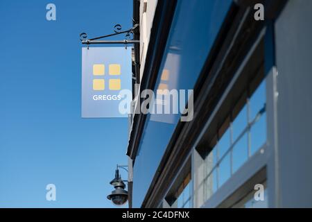 Un magasin de détail de restaurants de rue isolé et populaire au Royaume-Uni montrant son signe contre un ciel bleu clair. Banque D'Images