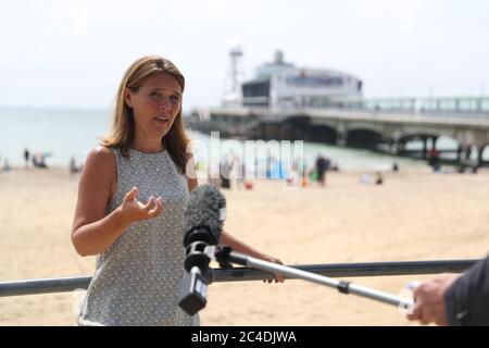 Le leader de Bournemouth, Christchurch et Poole Council Vikki Slade vous donne un entretien vidéo pendant que les gens se détendent sur la plage près de Bournemouth Pier. Trois hommes ont été poignardé dans un centre de villégiature populaire après qu'un incident majeur ait été déclaré lorsque des milliers de personnes qui cherchent un soleil se sont enferrées sur les plages au milieu de la vague de chaleur. Banque D'Images