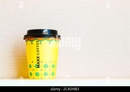 Une tasse de café à emporter jaune avec le nom de la chaîne de café Maxx inscrit au centre de la tasse. Banque D'Images