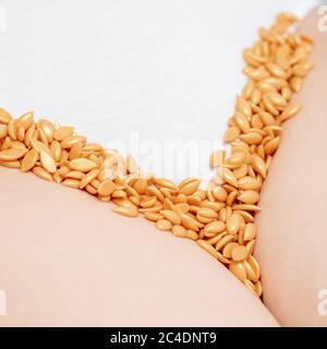 Gros plan de grains de cire ou de graines de suite sur la zone du maillot de la jeune femme Banque D'Images