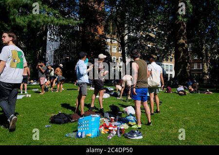 25 juin 2020. Des groupes de personnes se réunissent à Soho Square, Londres pour profiter du temps d'été malgré les règlements sociaux de distance Covid-19. Londres, Royaume-Uni. Banque D'Images