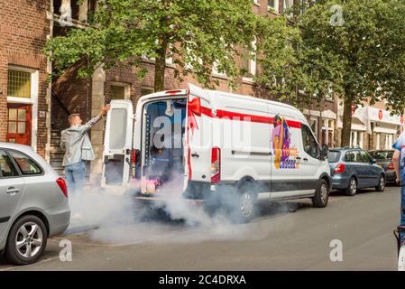 Un homme avec un saxophone devant son fourgon de fête dans la rue de la Haye Banque D'Images