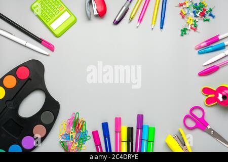 Fournitures scolaires et de bureau trombones, ciseaux, stylos, stylos à pointe feutre, taille-crayon, calculatrice, agrafeuse isolée sur fond gris Flat Lay Banque D'Images