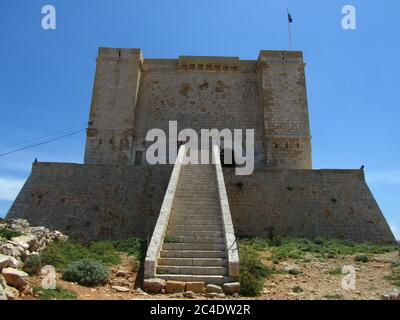 COMINO, MALTE - 27 avril 2014 : Tour Santa Marija, construite par les Chevaliers de l'ordre de Saint Jean, sur les falaises et la mer bleue sur l'île de Comino, Malte. PRI Banque D'Images
