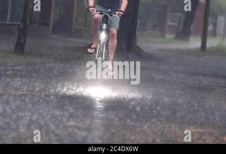 Potsdam, Allemagne. 26 juin 2020. Un homme fait un vélo à Babelsberg sous de fortes averses de pluie. Credit: Jens Kalaene/dpa-Zentralbild/dpa/Alay Live News Banque D'Images