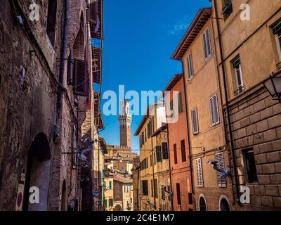 Torre del Mangia vue à travers les rues étroites de Sienne. Toscane, Italie. Banque D'Images