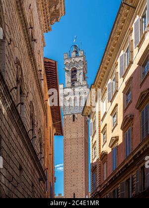 Torre del Mangia vue à travers les rues étroites de Sienne. Toscane, Italie. Banque D'Images