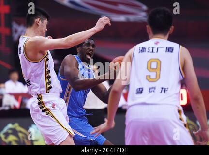 (200626) -- QINGDAO, 26 juin 2020 (Xinhua) -- Ekpe Udoh (C) des Ducks de Beijing tente de passer par la défense des Lions de Zhejiang lors d'un match entre les Lions de Zhejiang et les Ducks de Beijing lors de la ligue de l'Association chinoise de basket-ball (CBA) qui a récemment repris en 2019-2020 à Qingdao, dans la province de Shandong, en Chine orientale, le 26 juin 2020. (Xinhua/Li Ziheng) Banque D'Images