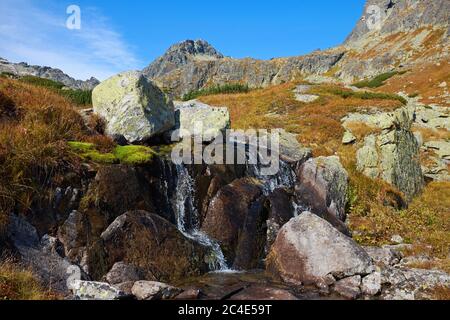 Petite cascade en automne haute montagne Tatras avec pierres et pics à la cascade et au lac de Skok en Slovaquie Banque D'Images