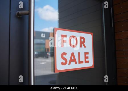 Gros plan de l'écriteau à vendre accroché à la porte d'un immeuble de bureaux moderne Banque D'Images