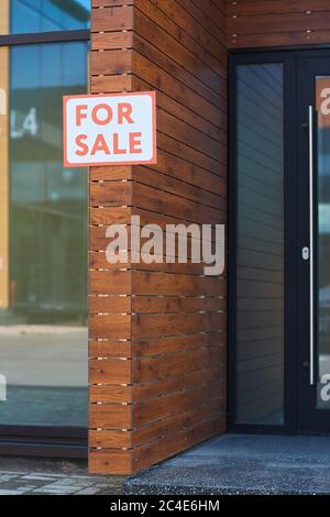 Image de l'écriteau à vendre accrochée au mur de la maison moderne Banque D'Images