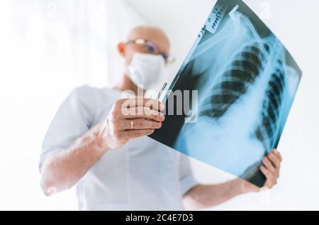 Mature Homme médecin examinant le patient de radiographie thoracique film poumons scanner au service de radiologie dans l'hôpital. Acquisition rapprochée. Test de radiographie du corps de l'acquisition Covid-19 Banque D'Images