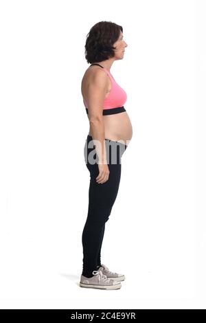 femme enceinte avec vêtements de sport isolée sur fond blanc, vue latérale Banque D'Images